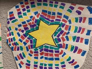 Photo shows painting of yellow star surrounded by dots of green, purple, red, blue and purple.